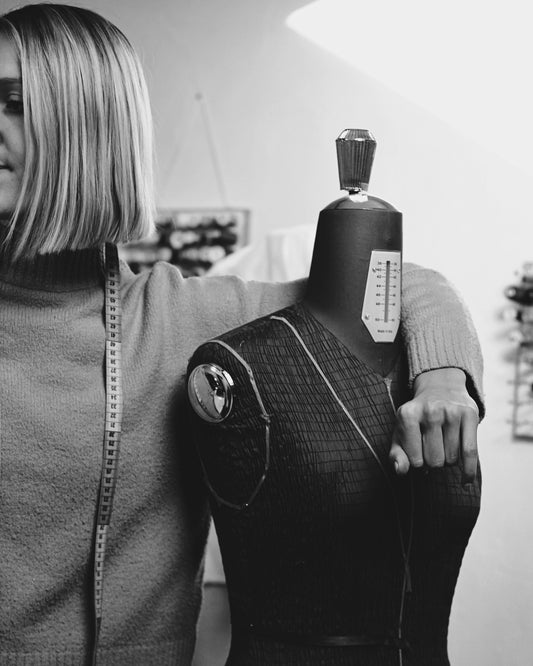 Créatrice accoudé au mannequin de couture.