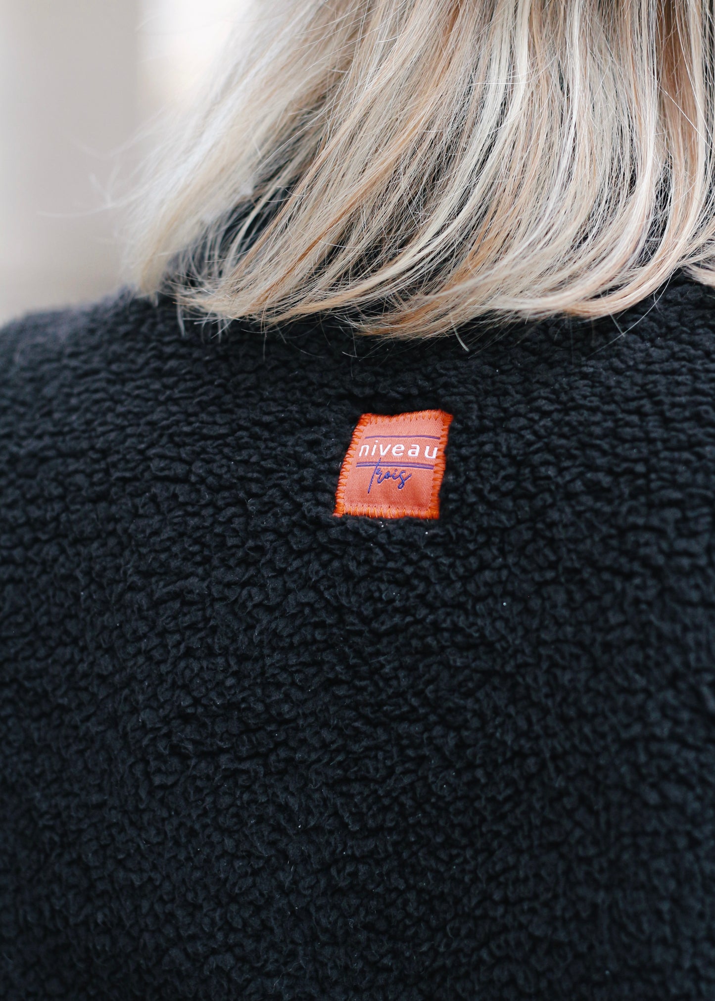 Sweat en Sherpa noir, zoom sur le logo dos