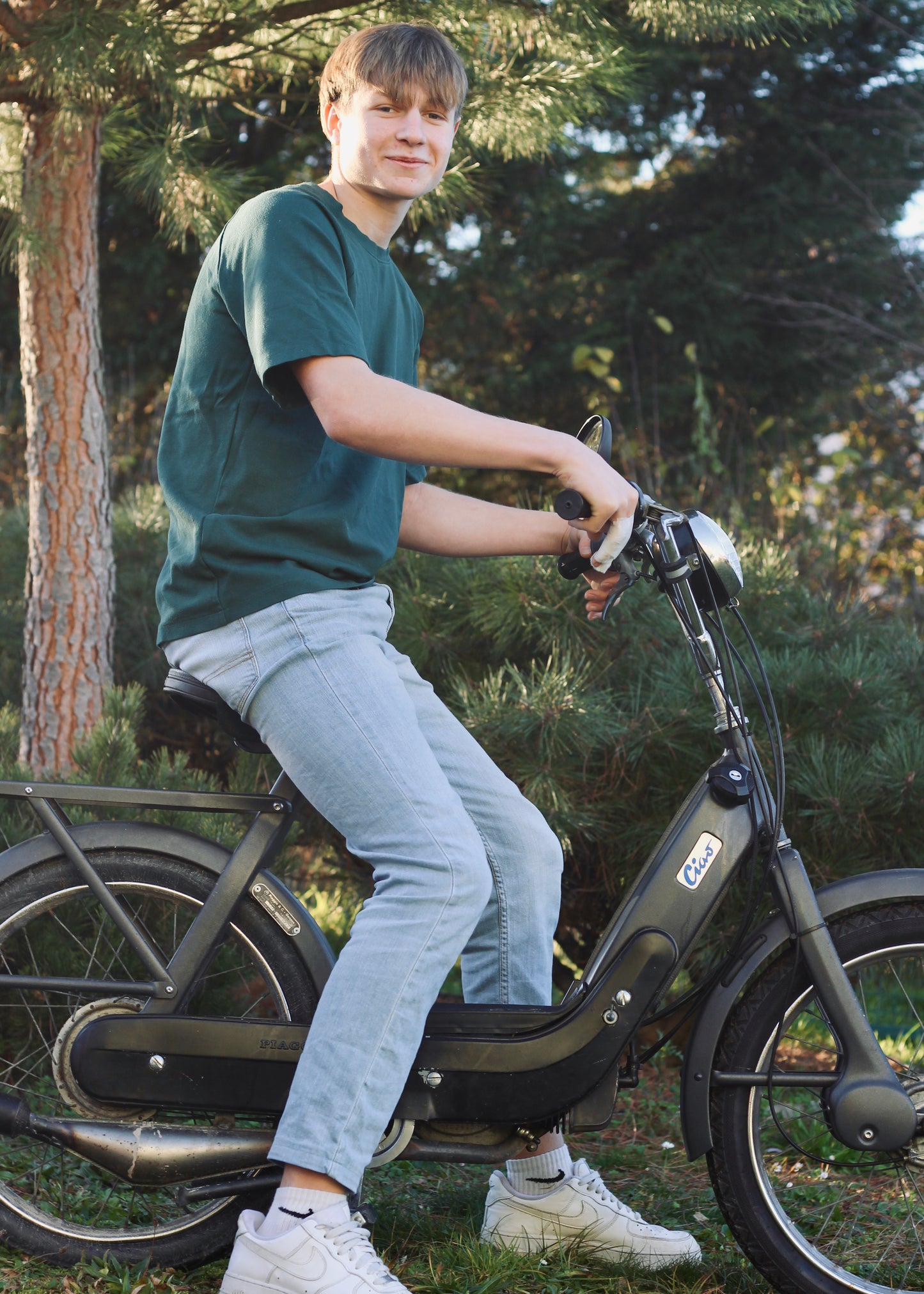 Jeune homme sur une mobylette, avec le t-shirt Dama vert.