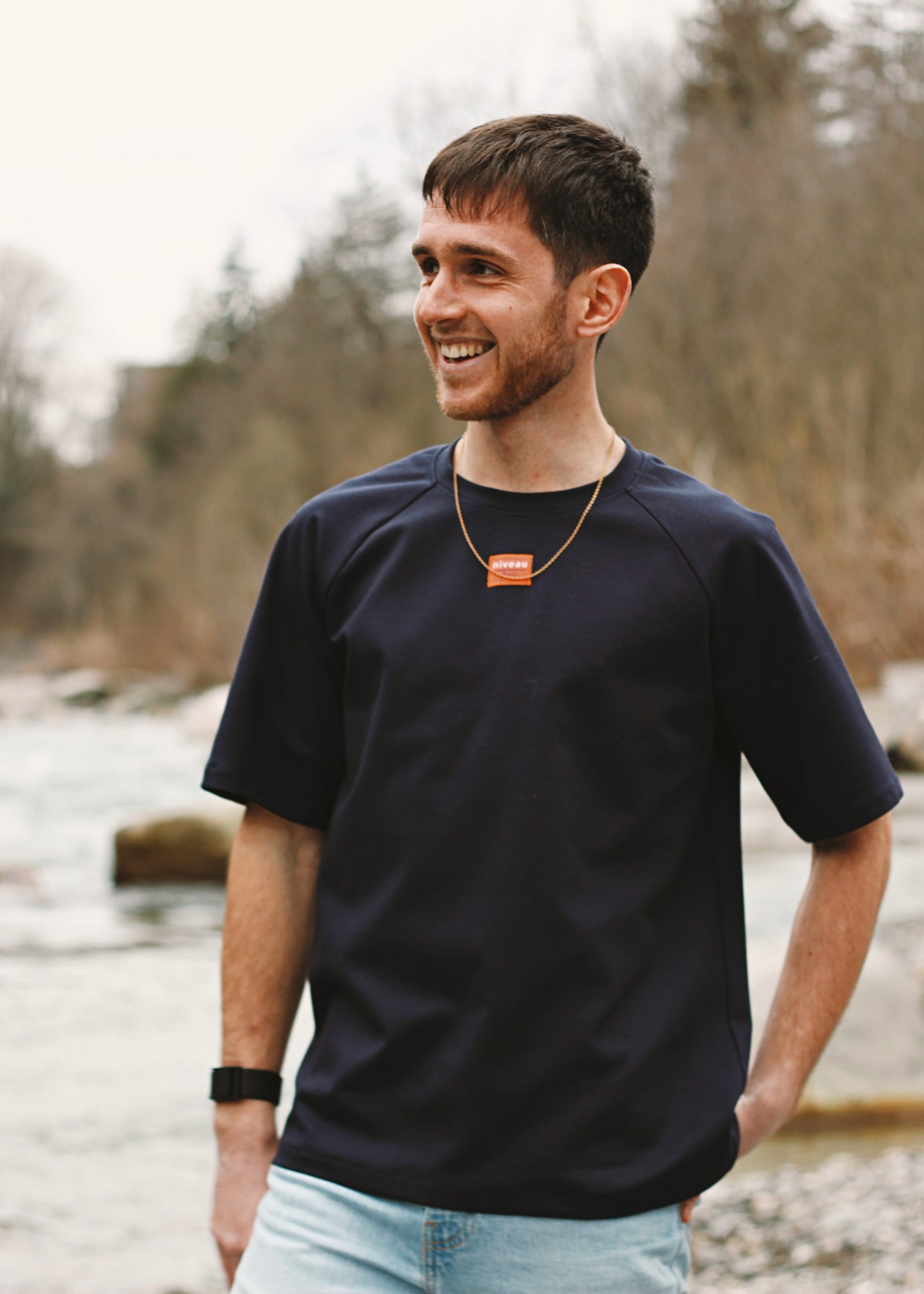 Homme souriant au bord de la rivière, portant le tshirt Dama marine.