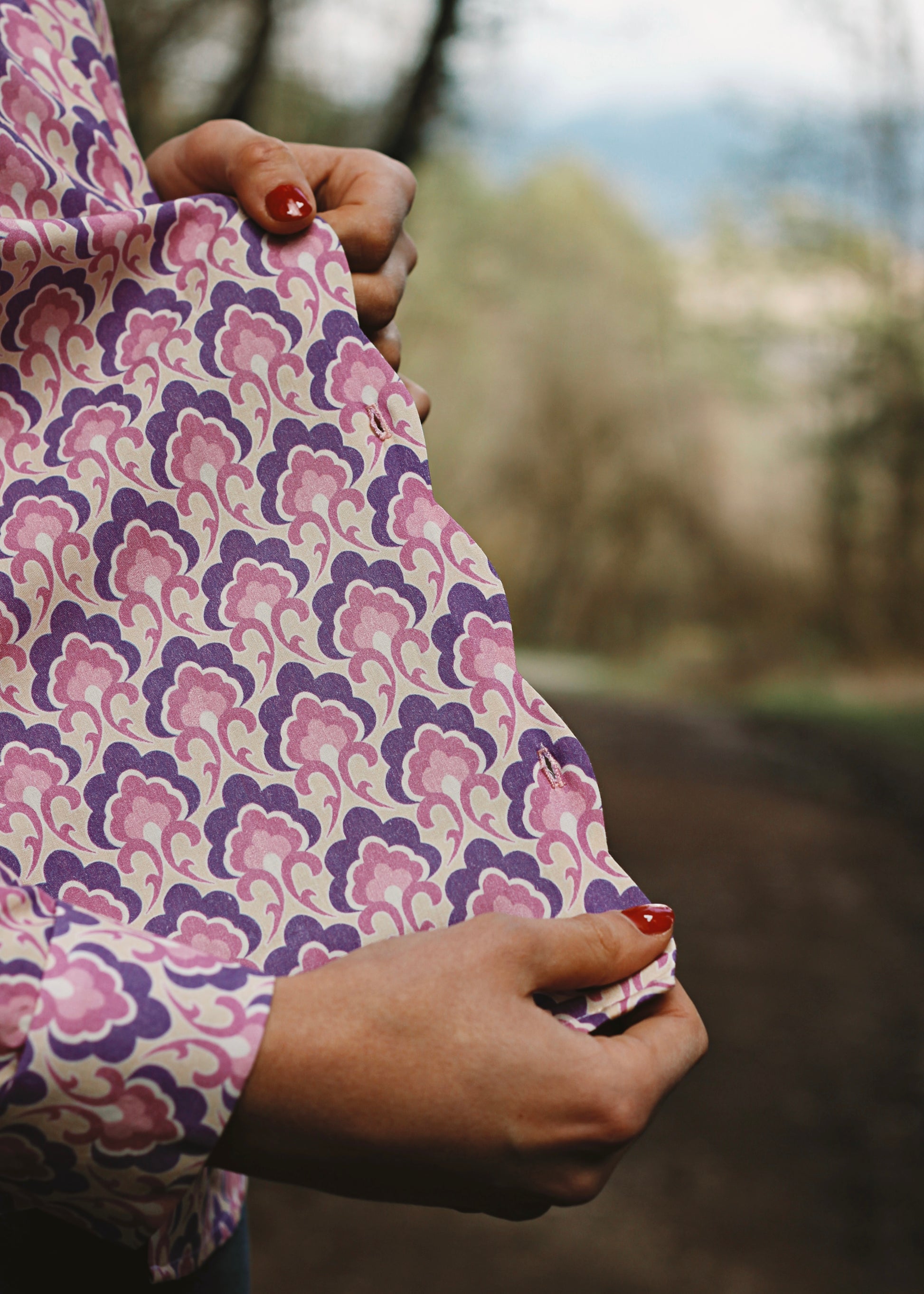 Femme portant le chemisier Iris lila, en forêt, zoom sur le détail du devant