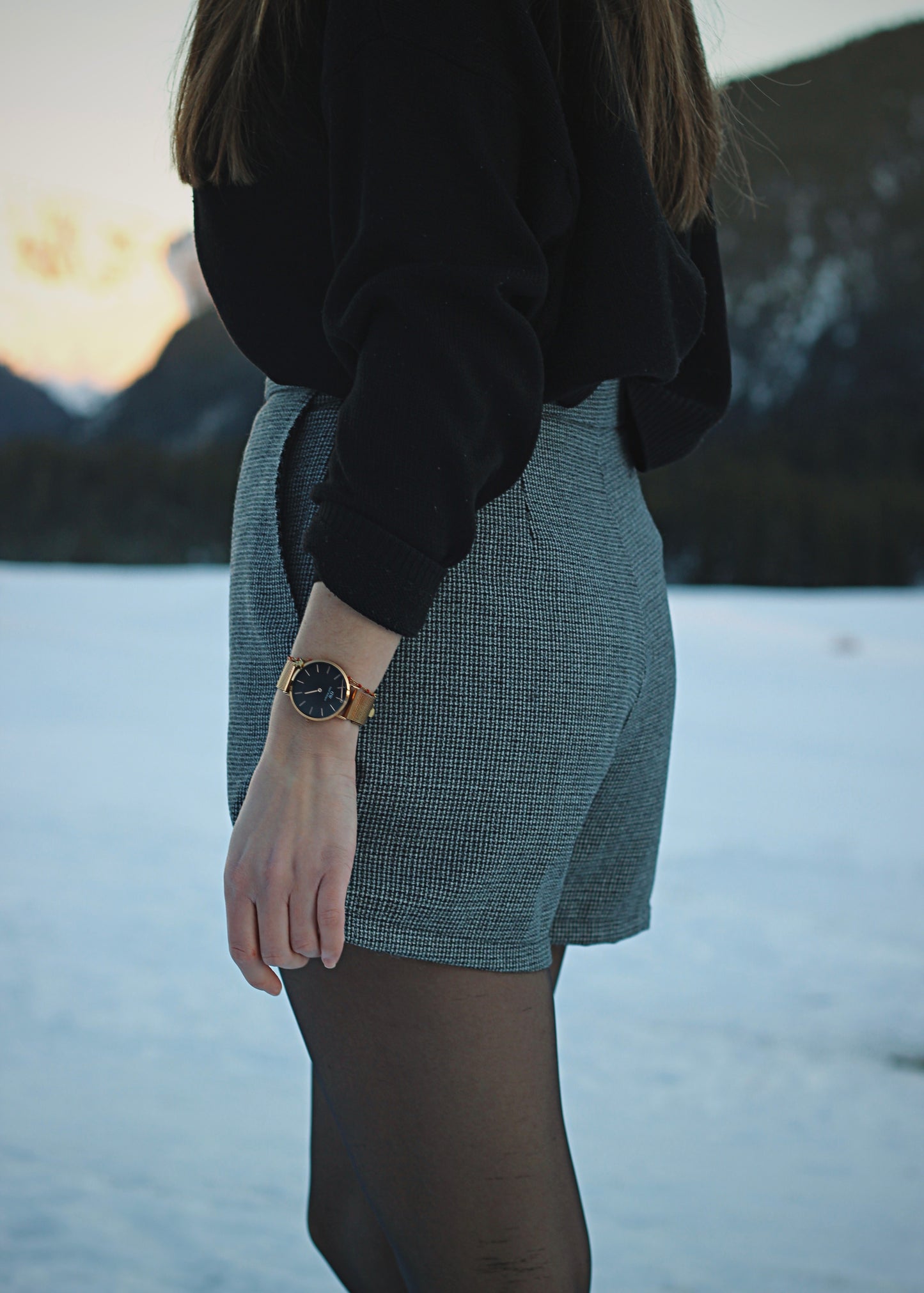 Jupe-short dans la neige, ambiance hivernale au soleil couchant, zoom sur la jupe de 3/4 dos.