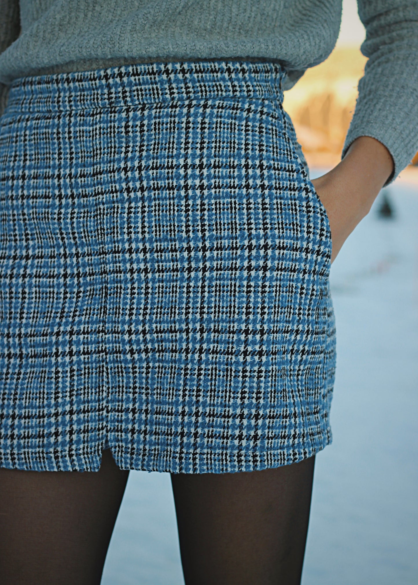 Zoom sur le motif du lainage de la jupe-short, carreaux bleu et noir.
